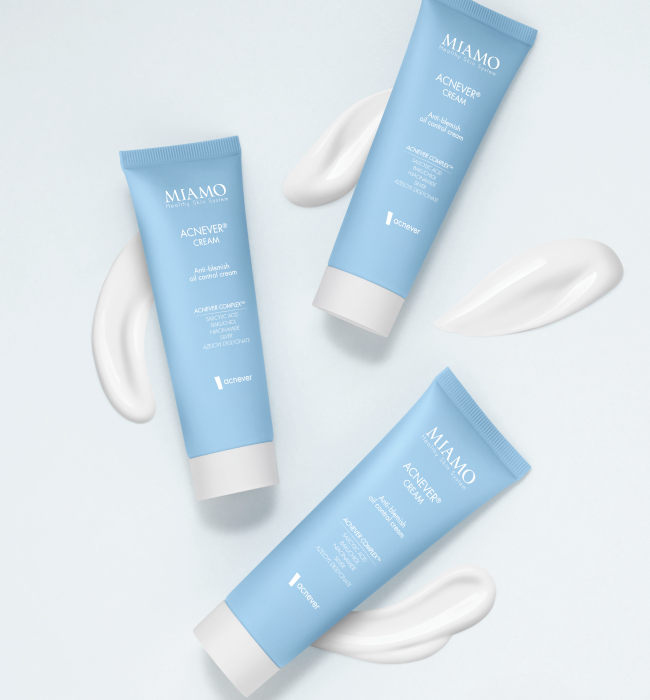 Tre creme ACNEVER® CREAM sdraiate su uno piano grigio fotografate dall'alto